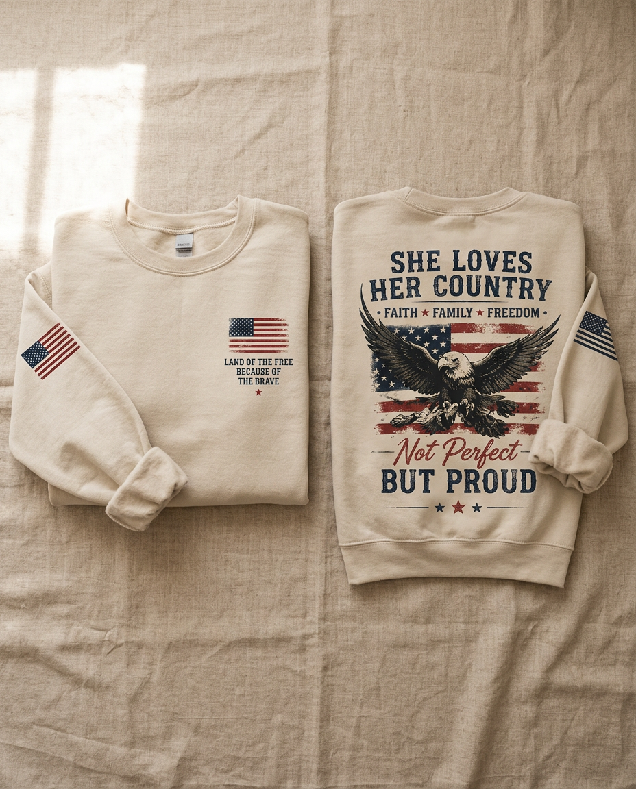 Two folded sand crewneck sweatshirts, one showing the flag and Land of the Free chest print, the other the She Loves Her Country eagle graphic on the back